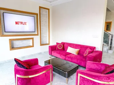a living room with a red couch and two chairs at Villa with private pool in Marrakech
