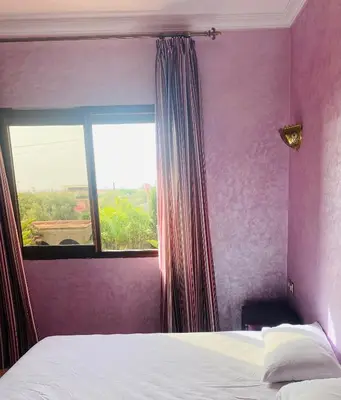 a bedroom with a bed and a large window at Villa privée in Marrakech