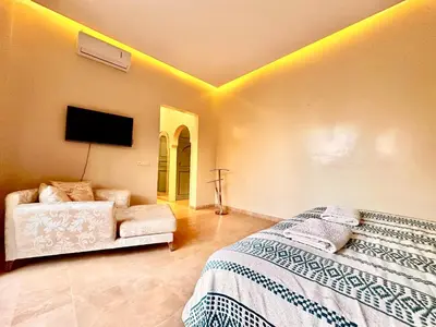 a bedroom with a bed and a couch at Villa Luxueuse avec Piscine & Vue sur le Golf in Marrakech