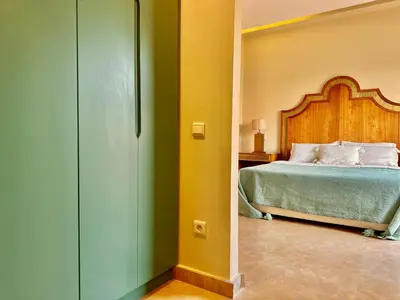a bedroom with a bed with a wooden headboard at Villa Luxueuse avec Piscine & Vue sur le Golf in Marrakech