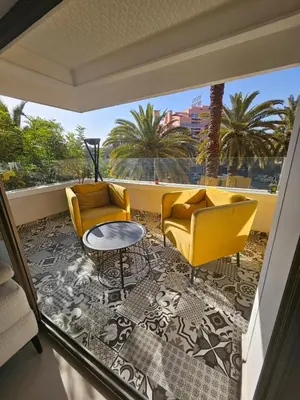 a living room with yellow chairs and a table at Luxury appartment hivernage in Marrakech