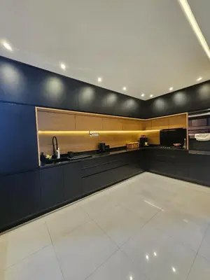 a kitchen with black cabinets and a white tile floor at Luxury appartment hivernage in Marrakech