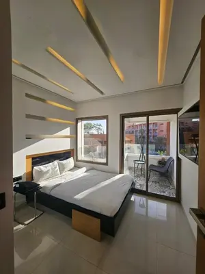 a bedroom with a large bed and large windows at Luxury appartment hivernage in Marrakech