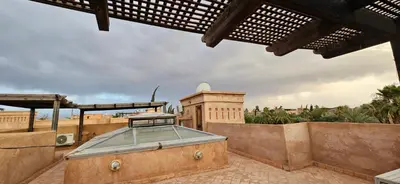 an outdoor patio with a hot tub on a roof at Riad-Style Villa in Marrakech in Marrakech