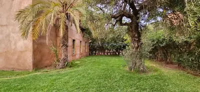 a yard with a palm tree next to a building at Riad-Style Villa in Marrakech in Marrakech