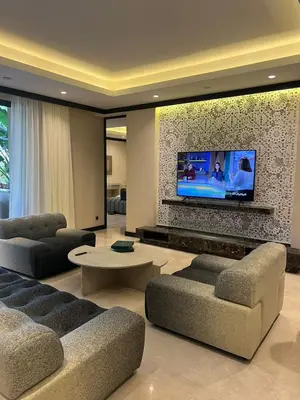 a living room with couches and a flat screen tv at Four Seasons Residences Marrakech in Marrakech