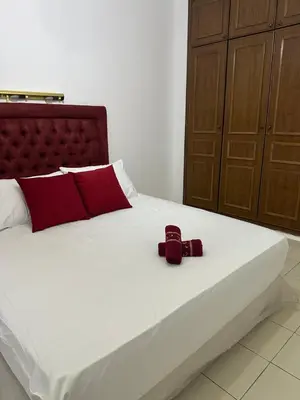 a white bed with two red pillows on it at Dar Al Amina in Marrakech