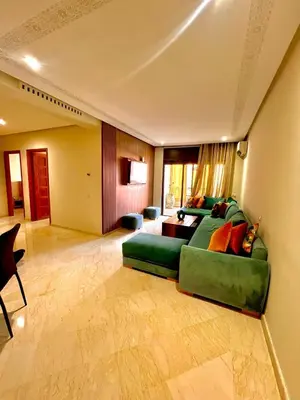 a living room with a green couch and a table at Jassman2 in Marrakech