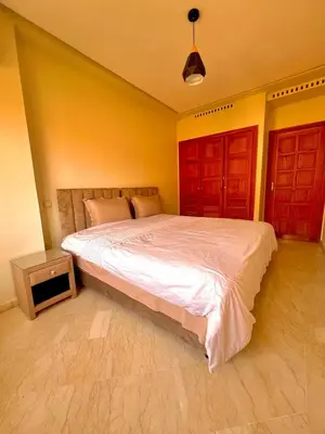 a bedroom with a large bed and two red doors at Jassman2 in Marrakech