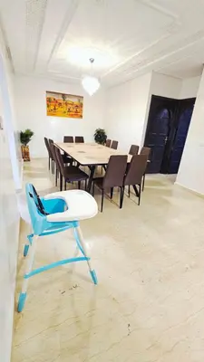 a dining room with a table and a blue chair at Magnifique villa avec bassin près de la Médina in Marrakech