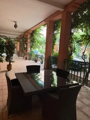 a table and chairs in a courtyard with trees at Résidence touristique Marrakesh in Marrakech