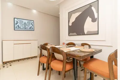 a dining room with a wooden table and chairs at appartement luxe golf prestigia in Marrakech