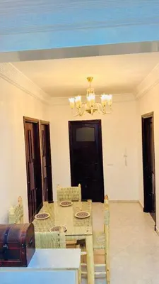 a dining room with a table and chairs and a chandelier at Spacieux appartement juste pour familles réservation juste pour les familles et les couples mariés in Marrakech