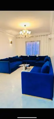 a living room with blue couches and a chandelier at Spacieux appartement juste pour familles réservation juste pour les familles et les couples mariés in Marrakech