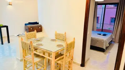 a dining room with a table and chairs and a bed at Spacieux appartement juste pour familles réservation juste pour les familles et les couples mariés in Marrakech