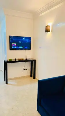a living room with a tv on a wall at Spacieux appartement juste pour familles réservation juste pour les familles et les couples mariés in Marrakech