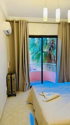 a bedroom with a bed and a large window at Spacieux appartement juste pour familles réservation juste pour les familles et les couples mariés in Marrakech