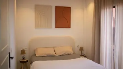 a bedroom with a bed and two paintings on the wall at Cosy Victor hugo in Marrakech
