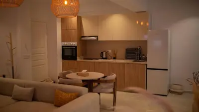 a living room with a couch and a table and a kitchen at Cosy Victor hugo in Marrakech
