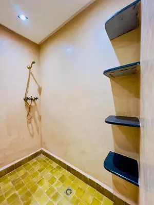 a bathroom with a spiral staircase and a tiled floor at bel appartement in Marrakech