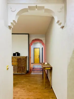 an archway in a room with a table and a hallway at bel appartement in Marrakech