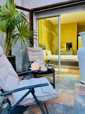 a living room with chairs and a glass table at bel appartement in Marrakech