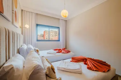 a living room with two beds and a window at 3BR Luxury Stay - Hivernage- Pool View - Parking Near M Avenue & Rail in Marrakech