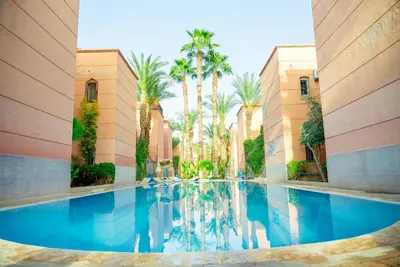 a pool in the middle of a building with palm trees at Riad Palm and Pool 2 in Marrakech