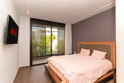a bedroom with a bed and a large window at jacuzzi, 2 pools, luxury villa in Marrakech