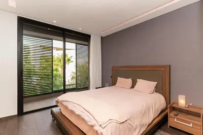 a bedroom with a large bed and a large window at jacuzzi, 2 pools, luxury villa in Marrakech