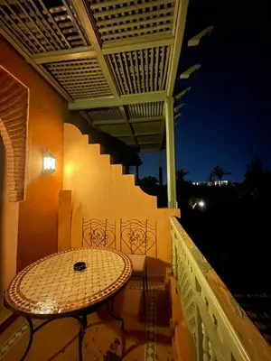 a table on the balcony of a building with a roof at Ma kech house in Marrakech