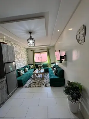 a living room with green couches and a table at Global riad nawal in Marrakech