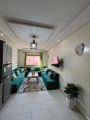 a living room with a green couch and a table at Global riad nawal in Marrakech