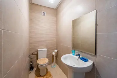 a bathroom with a sink and a toilet and a mirror at Cocon Sable piscine et parking in Marrakech
