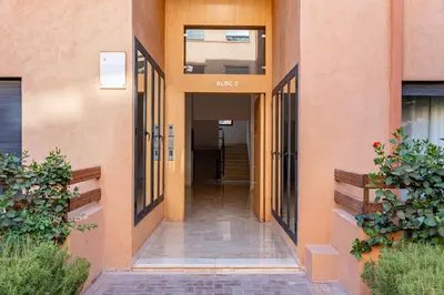 an empty hallway of a building with doors and plants at Cocon Sable piscine et parking in Marrakech