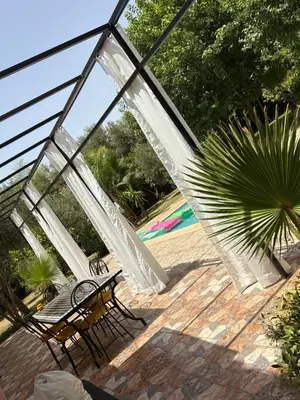 a glass patio with a bench and a palm tree at L ÉdenS in Marrakech