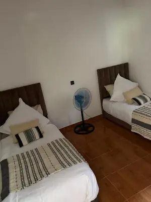 a bedroom with two beds and a fan at L ÉdenS in Marrakech
