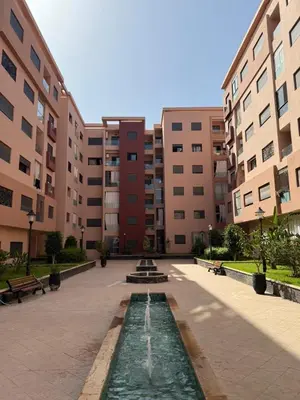 a fountain in the middle of a courtyard with buildings at Magnifique appart Moderne 2ch 4pax Tout Confort in Marrakech