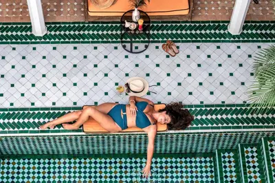 a woman in a swimsuit laying in a swimming pool at Marrakech Riads, NL Collection in Marrakech