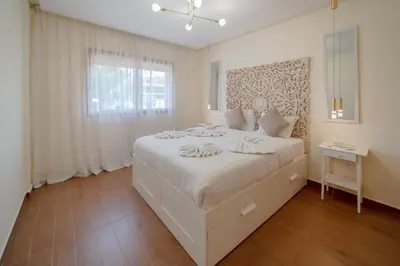 a white bedroom with a large bed and a window at Prestige de luxe avec piscine in Marrakech