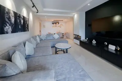 a living room with a large couch and a flat screen tv at Prestige de luxe avec piscine in Marrakech