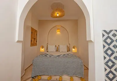 a bedroom with a black and white striped bed at Riad E&J Marrakech Médina 5 ch climatisées, piscine chauffée, EXCLUSIF in Marrakech