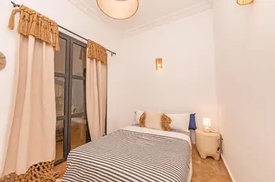 a bed in a room with a window at Riad E&J Marrakech Médina 5 ch climatisées, piscine chauffée, EXCLUSIF in Marrakech