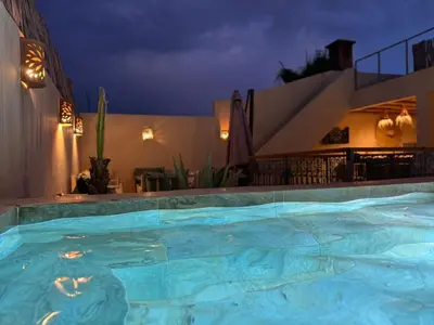 a large swimming pool at night at Riad E&J Marrakech Médina 5 ch climatisées, piscine chauffée, EXCLUSIF in Marrakech