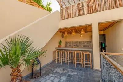 a patio with a bar in a house at Riad E&J Marrakech Médina 5 ch climatisées, piscine chauffée, EXCLUSIF in Marrakech