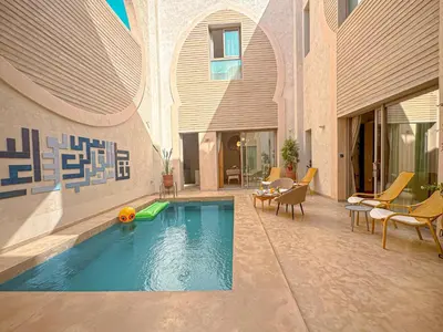 a swimming pool in the middle of a building at Riad Timija in Marrakech