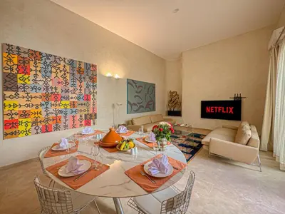 a living room with a table with chairs and a couch at Riad Timija in Marrakech