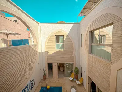 an external view of a building with a swimming pool at Riad Timija in Marrakech