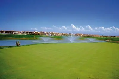 a golf course with a fountain in the middle of a green at Luxury Stay - Prestigia Golf City-3min - Airport in Marrakech