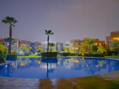 a large swimming pool with palm trees and buildings at Luxury Stay - Prestigia Golf City-3min - Airport in Marrakech